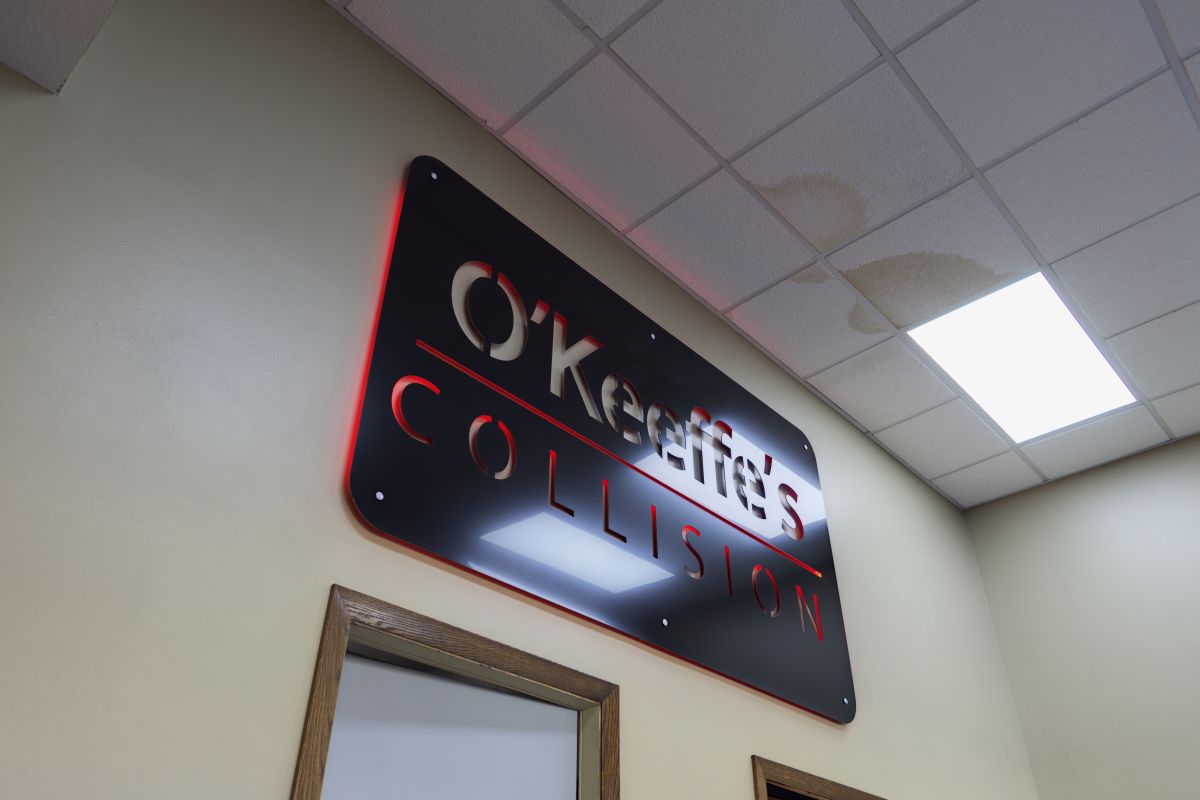 The black and red O'Keeffe's Collision metal sign in the front office