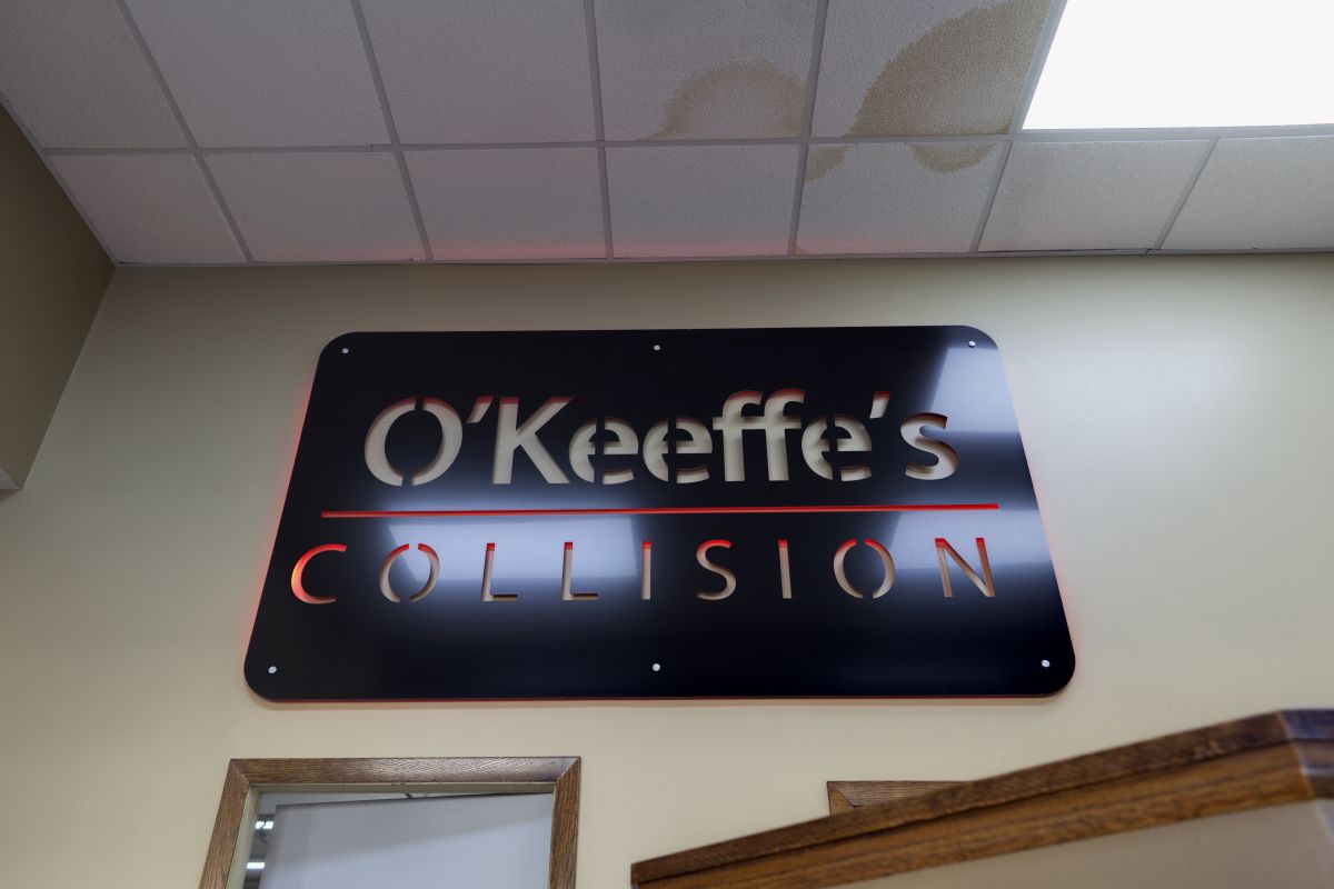 The black and red O'Keeffe's Collision metal sign in the front office