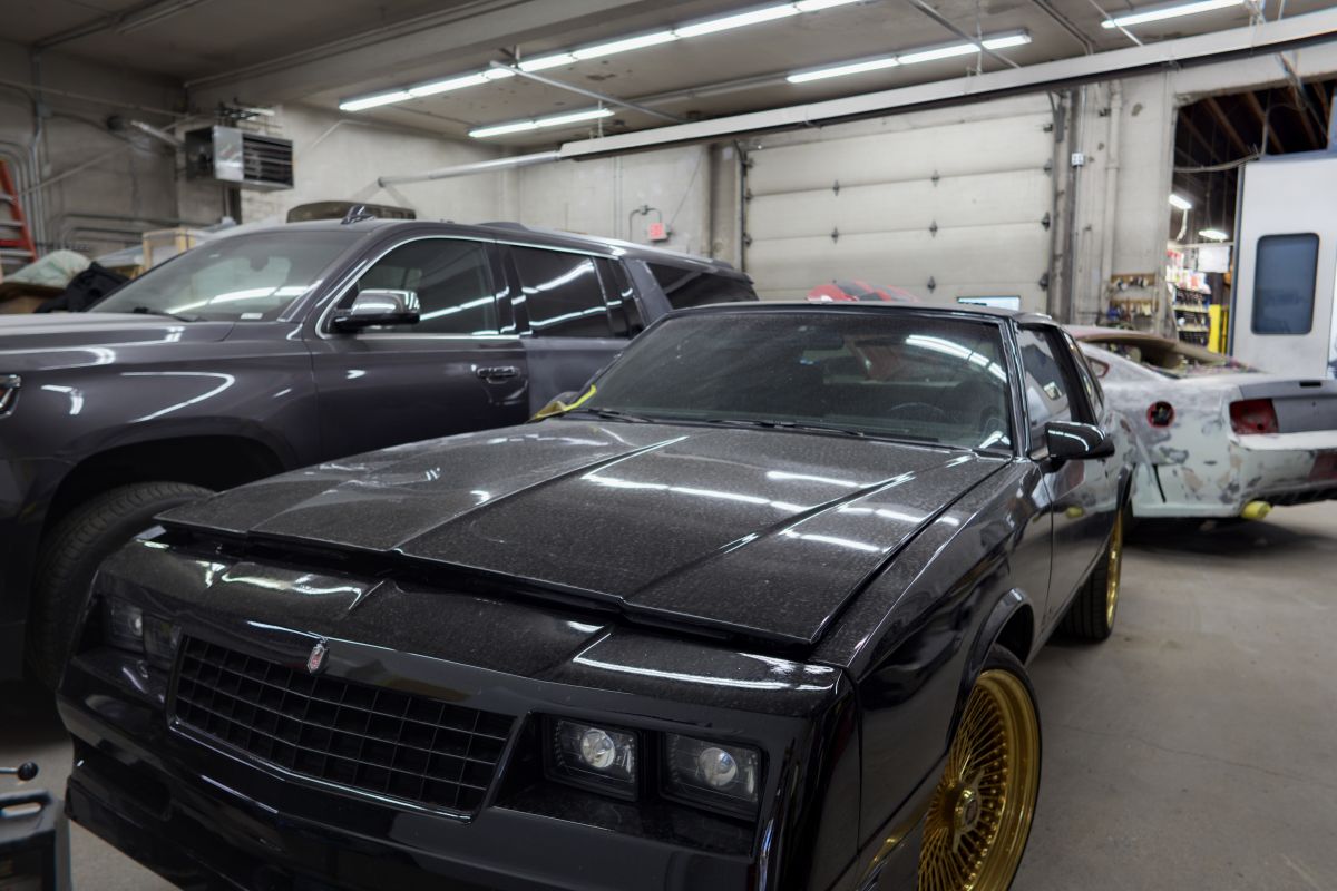 A black Monte Carlo on gold wheels on the shop floor